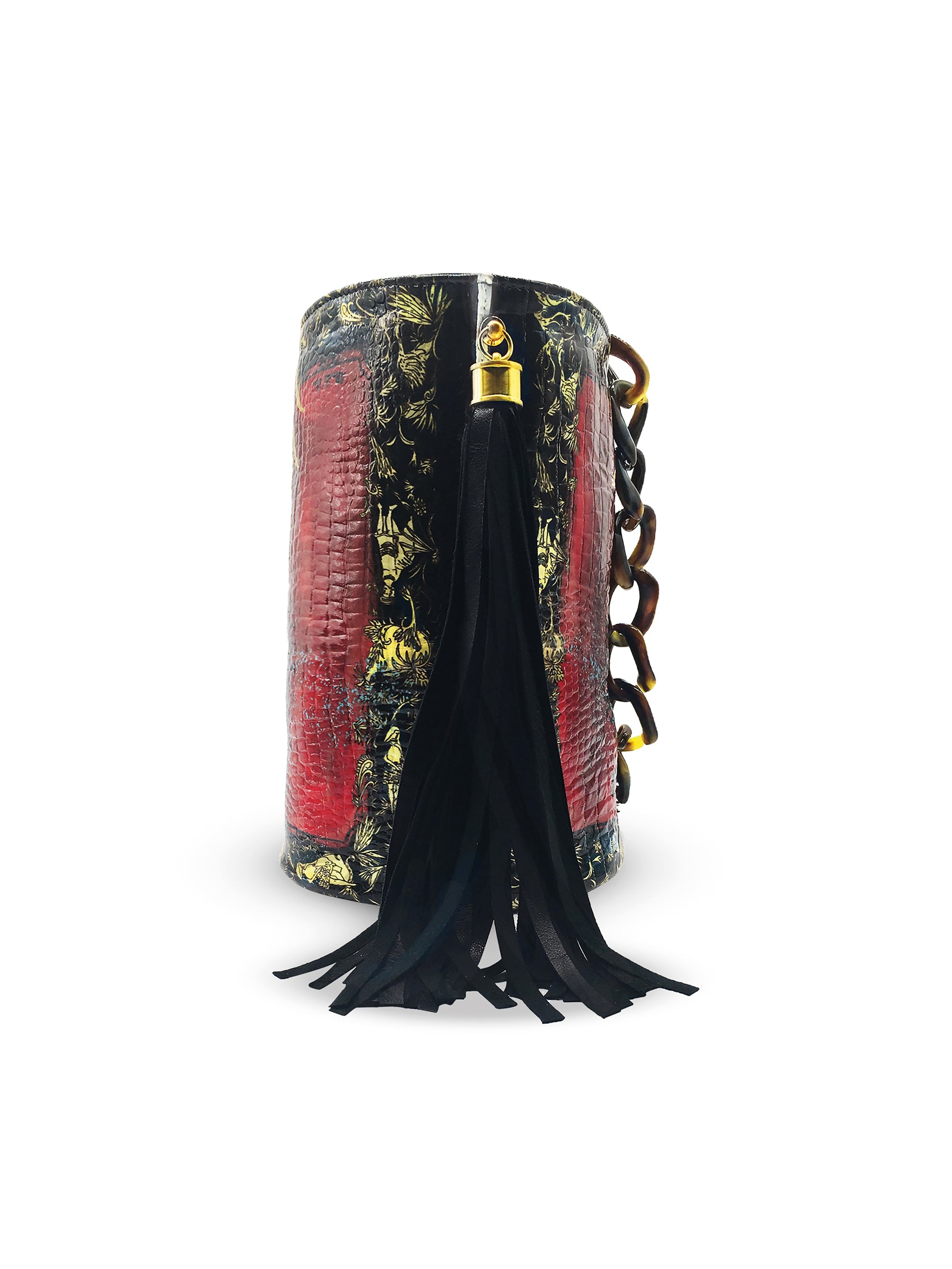 side view of red, black and gold printed glossy croc effect genuine leather bucket bag. 2 leather side tassels and resin linked chain handle