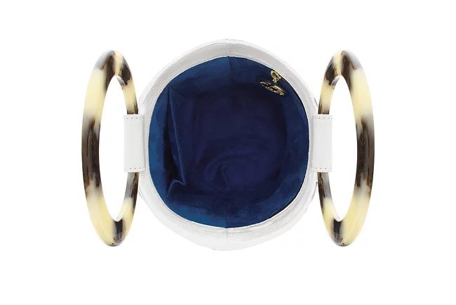 showing the blue fabric interior of the white leather bucket bag. Zip pocket and pouch pocket. resin handles